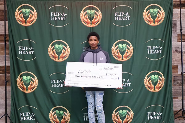 Young founder holding an award and ceremonial check
