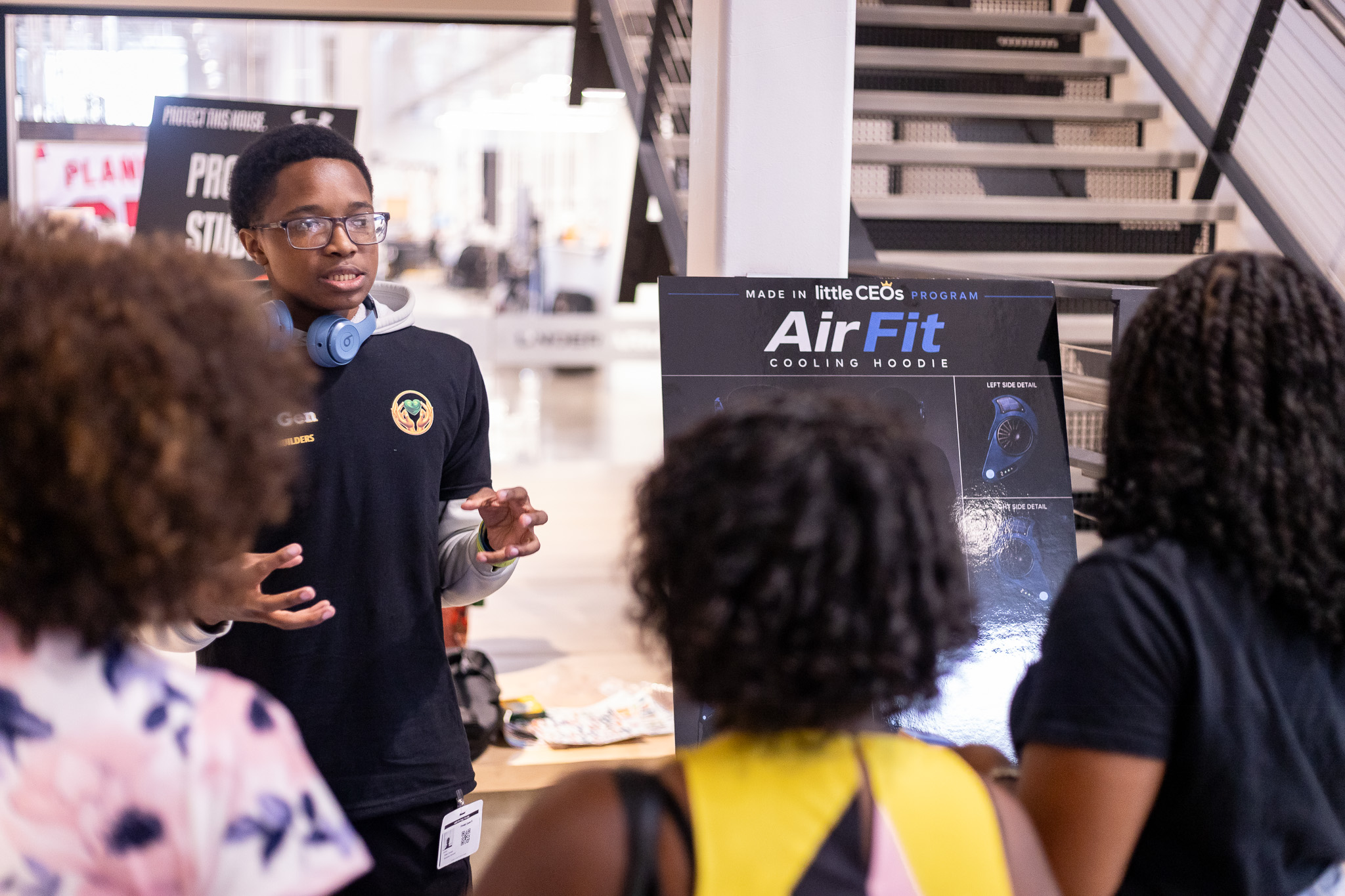 Young founders discussing their venture with an adult at a showcase